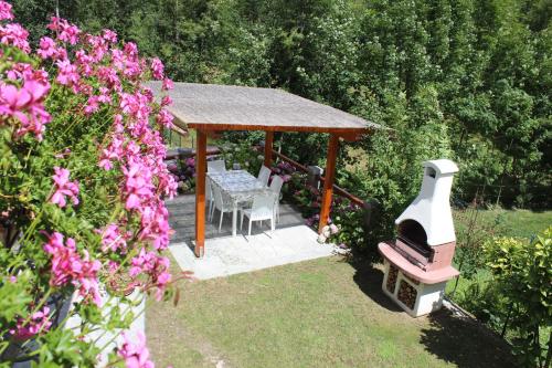 a gazebo with a table and a grill in a garden at Villa Giuly in Antronapiana