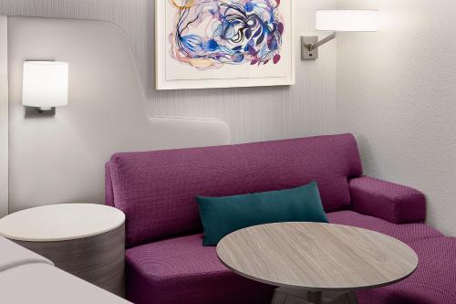 a living room with a purple couch and a table at Crowne Plaza Atlanta Perimeter at Ravinia by IHG in Atlanta