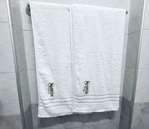 una toalla blanca colgada en una cabina de ducha en Naka Tranquil Suite with Ample Secure Parking, en Nakuru