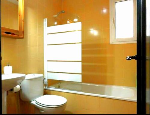 a bathroom with a toilet and a sink and a tub at Casa La Buganvilla 2 Aracena in Aracena