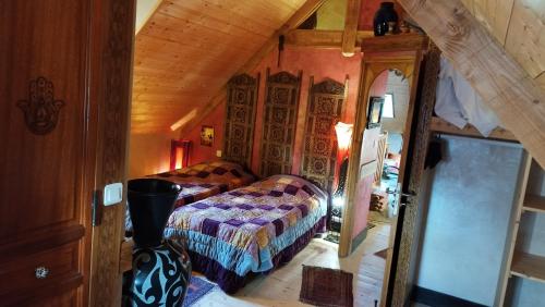 ein Schlafzimmer im Dachgeschoss mit 2 Betten und einem Spiegel in der Unterkunft Gite Esprit du Monde in Kervignac