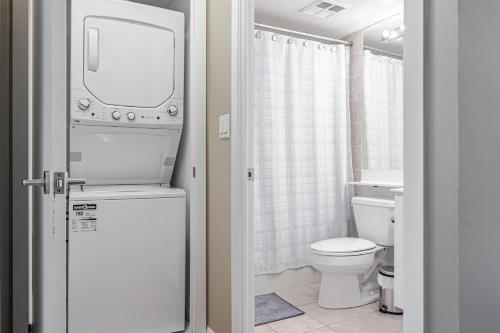 a bathroom with a white toilet and a sink at Fort York Apartments in Toronto