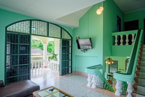 a living room with green walls and a tv at Bann Mangkud Khaolak in Khao Lak