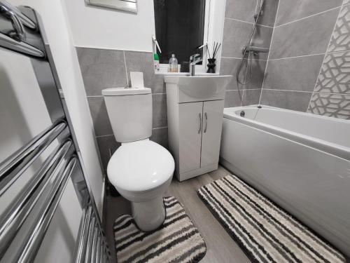a bathroom with a toilet and a tub and a sink at 3 Bed Home - Sleeps up to 5 - Coventry - Contractors, Families and Relocators in Coventry