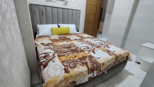 Una cama con una manta y una almohada amarilla. en Rabie en Fez
