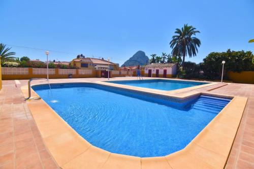 a large swimming pool with blue water in a resort at Bungalow Calpe con Piscina, Tenis, Parking in Calpe