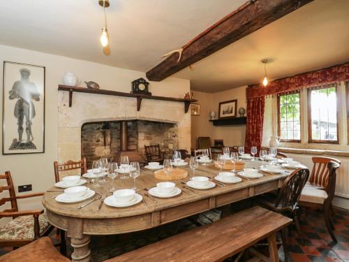 a large wooden table in a room with a fireplace at Reybridge House in Chippenham