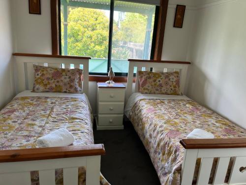 a bedroom with two beds and a window at Cheerful 2 bedroom house with a beautiful veranda in Geelong