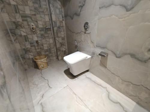 a white bathroom with a toilet and a shower at Hotel Beverly Palace Santacruz - Near BKC - Mumbai Airport T1 in Mumbai