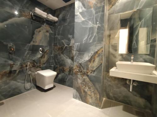 a bathroom with a toilet and a sink at Hotel Beverly Palace Santacruz - Near BKC - Mumbai Airport T1 in Mumbai