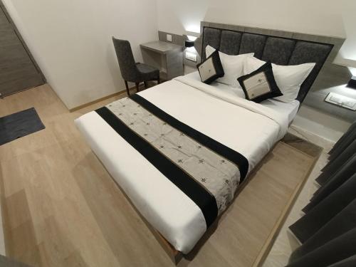 a bedroom with a large bed with a black headboard at Hotel Beverly Palace Santacruz - Near BKC - Mumbai Airport T1 in Mumbai