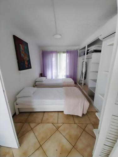 Un dormitorio con dos camas y una ventana. en Villa Violetta, en Punta del Este