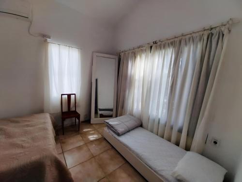 Un dormitorio con una cama y una ventana con cortinas. en Villa Violetta, en Punta del Este