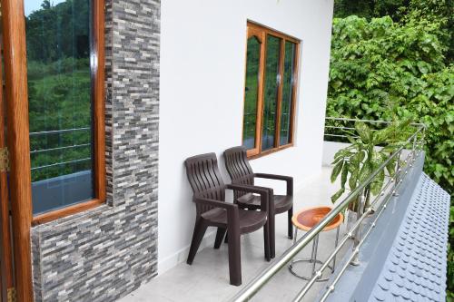 duas cadeiras na varanda de uma casa em coco view em Port Blair