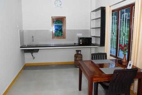 uma sala de jantar com uma mesa e uma janela em coco view em Port Blair