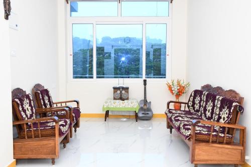 a living room with two chairs and a guitar at coco view in Port Blair