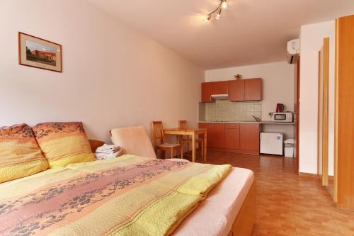 a bedroom with a bed and a small kitchen at Penzion U Zamku in Lednice