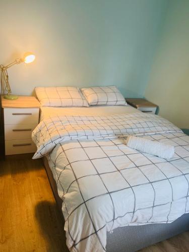 1 dormitorio con 1 cama con mesita de noche y lámpara en Ades en Leeds