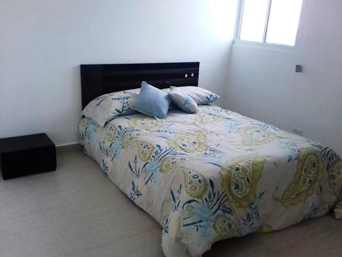 1 dormitorio con 1 cama con colcha de flores en Playa Blanca Coral Park, en Río Hato