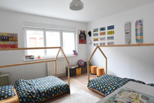 a bedroom with two bunk beds and a window at Maison cosy dans le centre ville de Lens in Lens