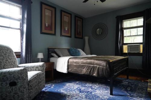 um quarto com uma cama e uma cadeira em Townhouse - Private 2nd Floor unit with Patio em Covington