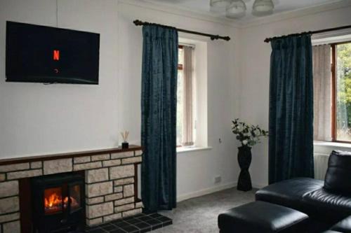 sala de estar con chimenea y sofá en North Coast country home(Portrush,Portstewart,Giant's Causeway), en Balnamore