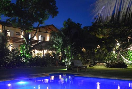 uma piscina em frente a uma casa à noite em Chill Mango em Paracuru