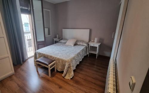オロットにあるApartment Sant Francescのベッドルーム1室(ベッド1台、テーブル2台、窓付)