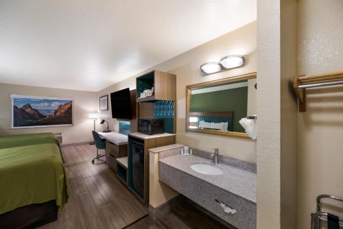 a hotel room with a bathroom with a sink and a bed at Quality Inn Alpine in Alpine