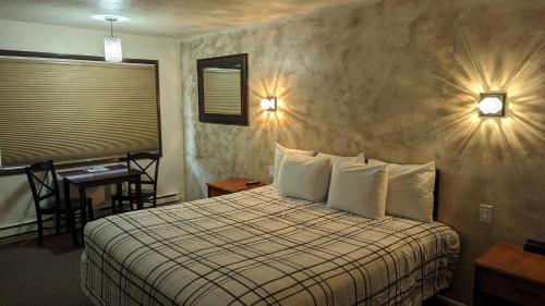 a hotel room with a bed and a table and a desk at High Desert Inn in Salina