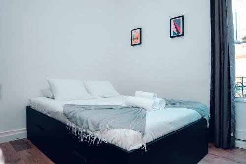 a bed with white pillows on it in a room at Guest House Arroios Rooms in Lisbon