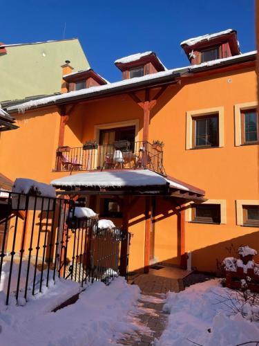 バンスカー・シュチャヴニツァにあるGoldapartmanの正面に雪が積もったオレンジ色の家