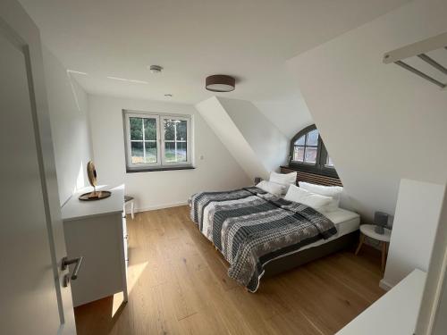 a white bedroom with a bed and a window at Reethaus Mellnitz in Mellnitz