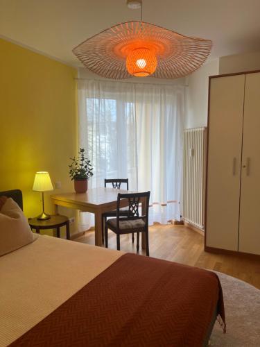 a bedroom with a bed and a table and a chandelier at Privatzimmer mit Balkon in Munich