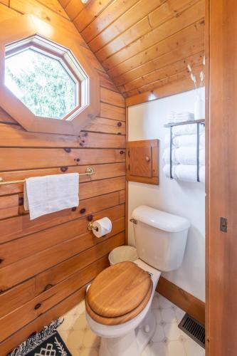 a bathroom with a toilet with a wooden wall at The Lodge at Fields of Home in Millersburg