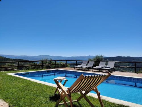 a wooden chair sitting next to a swimming pool at A Casa da Japoneira CB in Rebordões