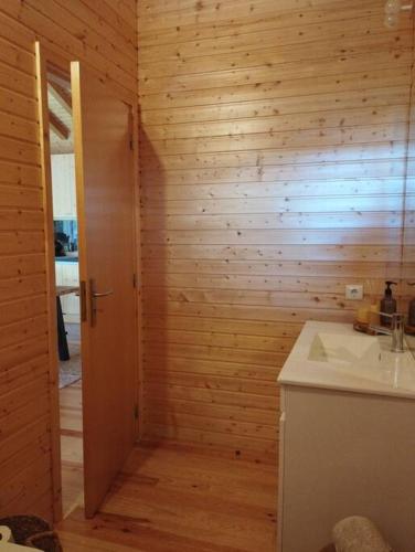 a bathroom with a sink and a wooden wall at A Casa da Japoneira CB in Rebordões