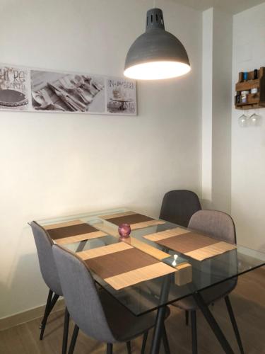 a dining room table with chairs and a lamp at Apartamento Migdia-Moraira in Moraira