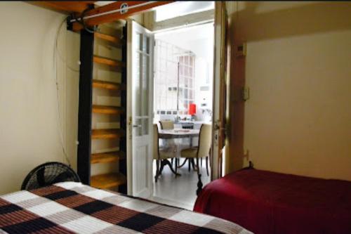 1 dormitorio con 1 cama y comedor con mesa en Amplio departamento en Villa Devoto en Buenos Aires