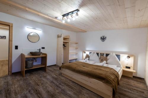 a bedroom with a large bed and a wooden ceiling at Kummererhof in Itter