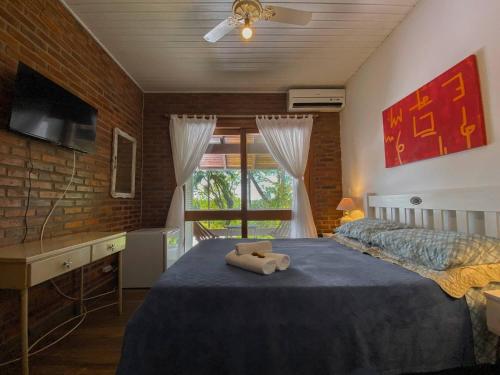 un dormitorio con una cama con dos animales de peluche en Morada das Bromélias, en Torres