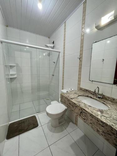 y baño con aseo, lavabo y ducha. en Apartamento em Porto Belo, en Porto Belo