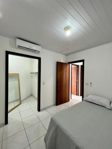 1 dormitorio con cama y espejo. en Apartamento em Porto Belo, en Porto Belo