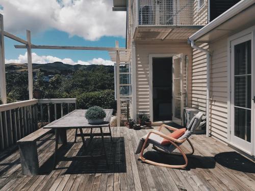 a wooden deck with a table and a chair at Cottage House in Wellington
