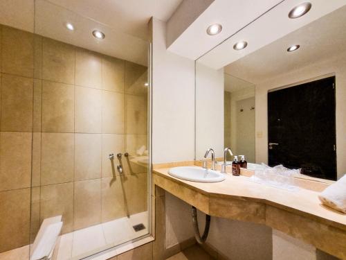 a bathroom with a sink and a shower at Howard Johnson Hotel & Convention Center Madariaga - Carilo in Carilo