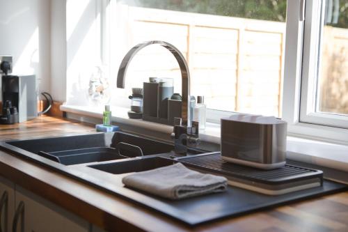 a kitchen counter with a sink and a sink at Chine Wood Retreat - Walk to the beach and the lovely Westbourne - Free parking in Bournemouth