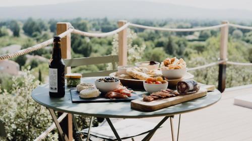 una mesa con un plato de comida y una botella de vino en LE CABANON 2.42, en Le Thor