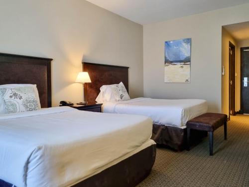 una habitación de hotel con 2 camas y una lámpara en Howard Johnson Hotel & Convention Center Madariaga - Carilo en Cariló