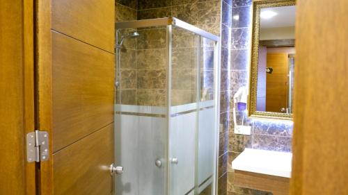 a bathroom with a shower with a sink and a mirror at Hotel Labella Bergama in Bergama