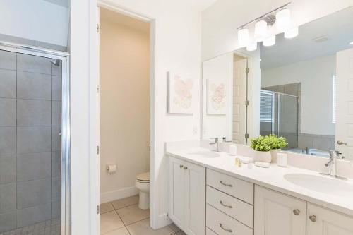 - une salle de bains blanche avec deux lavabos et une douche dans l'établissement EC459 - Fashionable Oasis with Themed Bedrooms at Encore, à Orlando